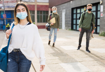 Portrait of girl teen student in protective face mask on her way to college in sunny spring day