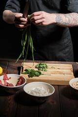 Chef preparing greens for cooking noodle dish