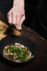 Chef squeezing lime to pho bo