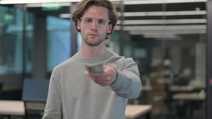 Portrait of Young Man Counting and Giving Dollars