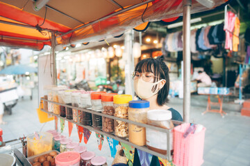 Fototapeta na wymiar Young adult asian foodie woman order asia dessert wear face mask for virus.