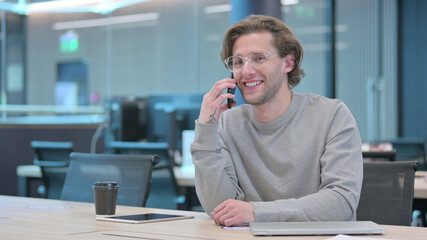 Young Man Talking on Phone in Office