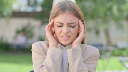 Outdoor Portrait of Businesswoman having Headache