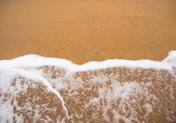 White soft foam wave on sand beach at coast of sea free space and flat lay. tropical ocean nature on day for tourist travel summer holidays vacation relax outdoor or background texture concept.