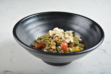 trio quinoa grain salad bowl with avocado, tomato, pea bean, carrot and brown rice in black bowl in white marble healthy poke bowl menu