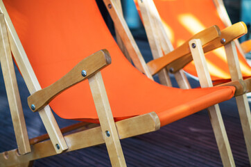 Folding wooden deckchair or beach chair. Armchair, Still life shot of two deck chairs on the beach