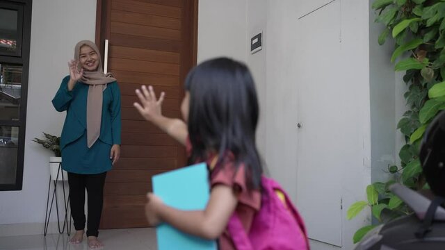 happy kid wave goodbye to mother before going to school in the morning