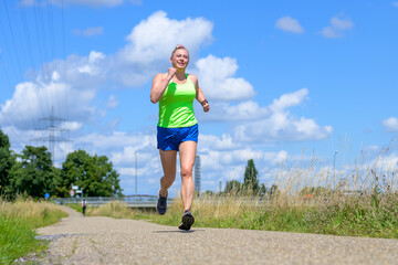 Fit healthy woman running or jogging along a rural footpath