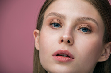 portrait of a girl. Female beauty. Close-up studio shot of beautiful teenage girl with delicate makeup posing against pink background