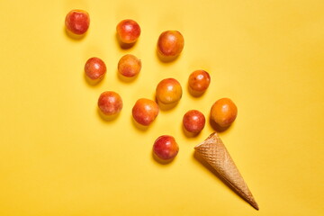 Group of scattered peaches and empty waffle cone