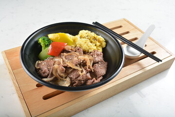 stir fried bbq bulgogi beef rice bowl with scrambled eggs and fried vegetable salad in black bowl in white marble healthy poke bowl menu
