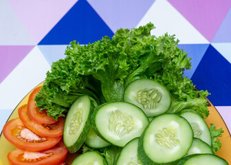 Vegetable in a plate on multicolor background.