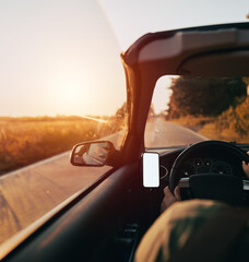 Mockup of the mobile phone at the driver's dashboard during a summer trip. Summertime adventure in...