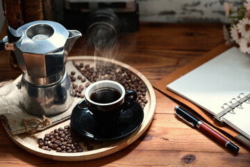 Coffee cup and moka pot on wooden table.
