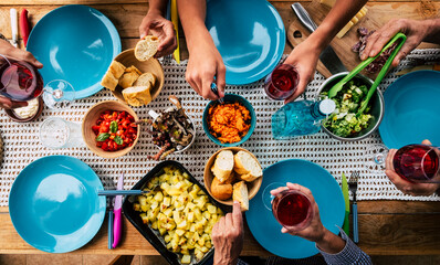 Top view of table full of food and riends enjoying event together - blue dishes and colorful...