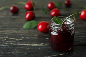 Cherry jam and ingredients on rustic wooden table