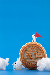 Miniature creative astronauts landing on the moon on mooncakes