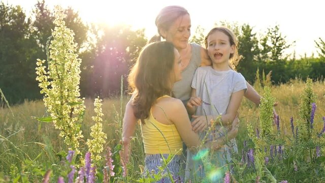 Cute child girl with her young mother and senior grandmother are having picnic during summer outdoor in nature, mothers day, happy retirement, multi generation family