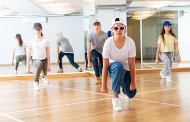 Positive teenage girls and boys training hip hop in dance studio, dance classes for teens