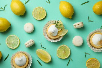 Lemon cupcakes, macaroons and ingredients on mint background