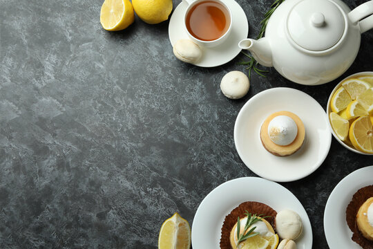 Concept of tasty breakfast with lemon cupcakes and macaroons