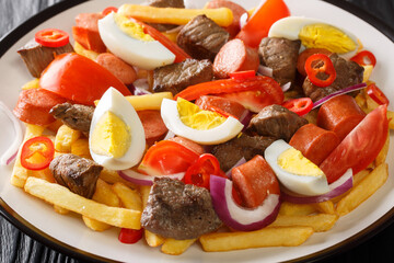 Bolivian Pique A Lo Macho is a dish prepared with cooked meat and sausage served over fries and...