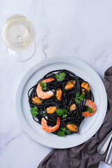 Black spaghetti pasta with seafood, shrimps, mussels and parsley