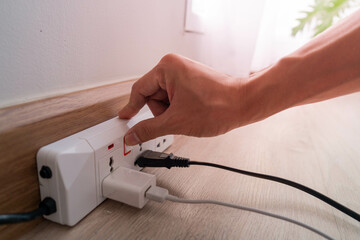 Save electricity, energy saving and environmental protection. Man's finger press on the button to...