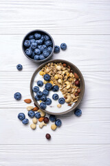 Bowl of healthy breakfast with granola, yogurt, fresh berries and nuts