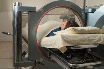 Hyperbaric treatment machine with a woman in it