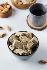 Halva slices in a bowls and coffee mug. Oriental sweetness. 
