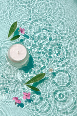 Cosmetic product, collagen cream on water with drops. Jar of moisturizing cream on aqua surface with waves in sunlight