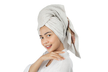 attractive girl with bath towel on head smiling at camera on gray background