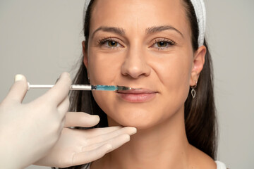 Portrait of a young satisfied woman on a lip filler injection procedure