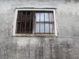 Fototapeta na wymiar vintage window with rusty bars on the aged wall design for ancient concept