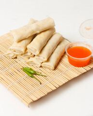 Spring roll cake isolated on white background. Lumpia is a typical Semarang cake. The spring roll cake is not fried, so it has a soft texture. This cake tastes sweet and savory. Focus blur.