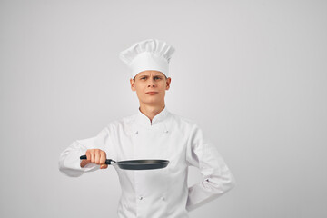 man in chef's clothes Frying pan in hands cooking professionals work