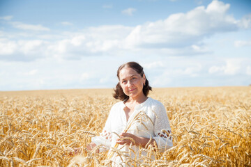 Russian elderly woman walking through   wheat field.