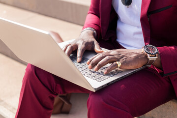 hands of a black man working with his laptop