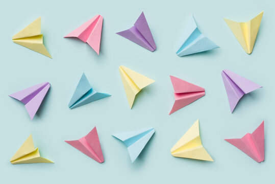 Handmade multicolor paper origami plane collection isolated on blue background