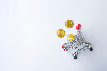 golden bitcoin in shopping cart on white table background. top view