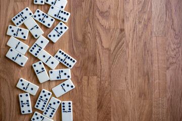 Fototapeta na wymiar White dominoes on the wooden background, top view. Board game. Place for text