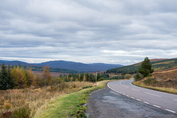 Road with Scenic Landscape View of Mountain, Forest in Scottish Highlands. Concept of Road trip, vacation.