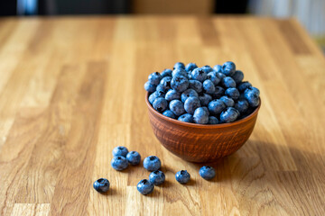 Blueberries in clay bowl on a wooden table. Healthy breakfast