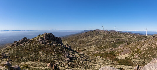 Ultra panoramic view at the Caramulo mountains, with wind turbines and blue sky, Serra da Estrela mountains as background - obrazy, fototapety, plakaty