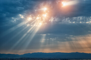 Beam of light through the clouds. Rays of light shining through clouds. Celestial entity over the...