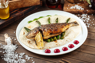 Dish of gourmet grilled dorada fish on the wooden background