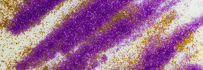 Fototapeta na wymiar Festive or glamorous background. Gold and purple sparkles scattered on a white background.