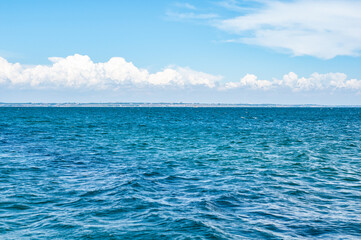 Obraz premium Empty landscape with blue sea water under dramatic cloudy sky with clouds.