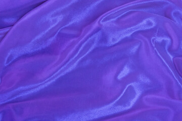 Rippled purple silk fabric background. Closeup of purple drapery cloth or satin, luxury and elegant violet texture 